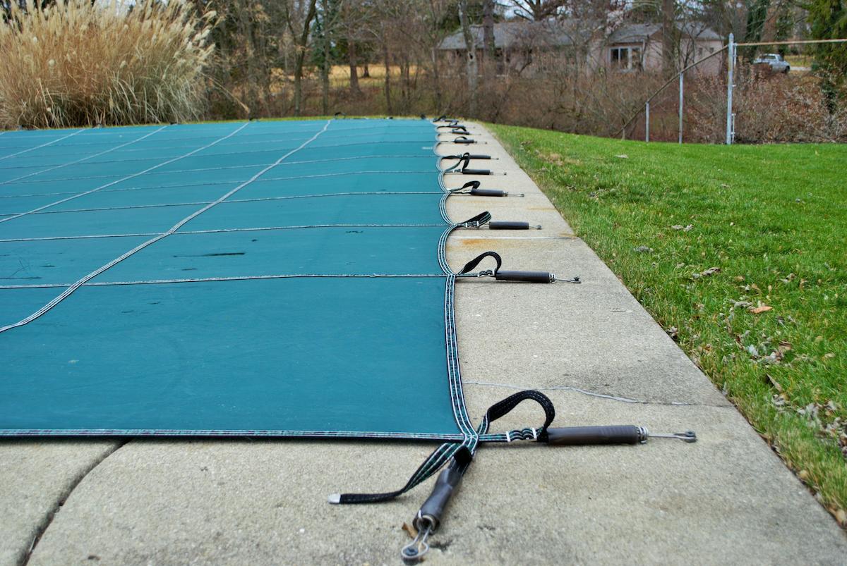 Piscine en hivernage avec une bâche.