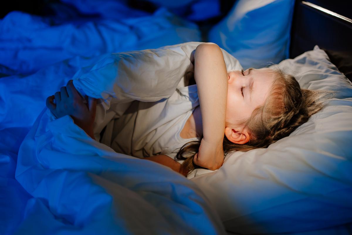 Enfant dans un lit gêné par l'humidité.