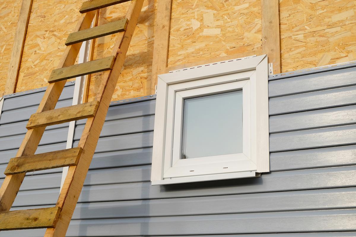 Pose de bardage en PVC sur une façade. 