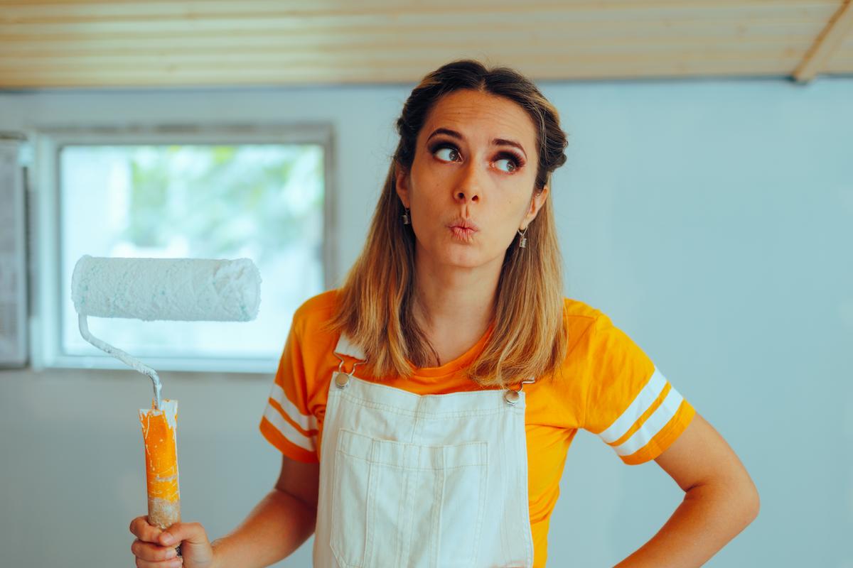 Femme tient rouleau de peinture