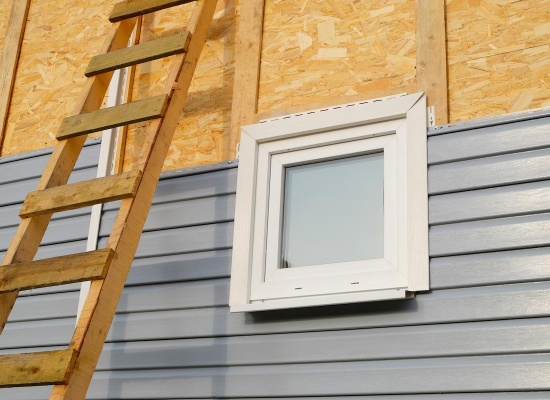 Pose de bardage en PVC sur une façade. 