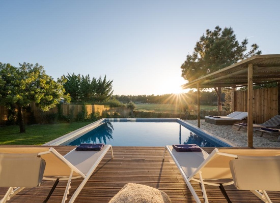 Deux transats sur une terrasse devant une piscine