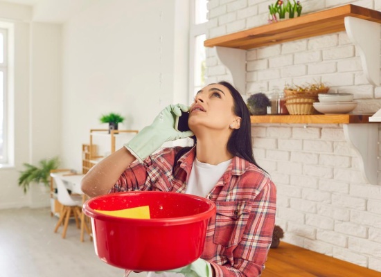 femme désemparée à cause d'une fuite d'eau