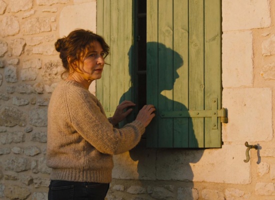 femme qui ferme ses volets battants à la fin de la journée