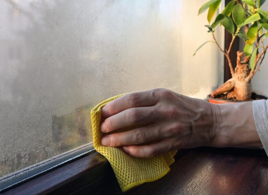Personne nettoie la condensarion sur une fenêtre