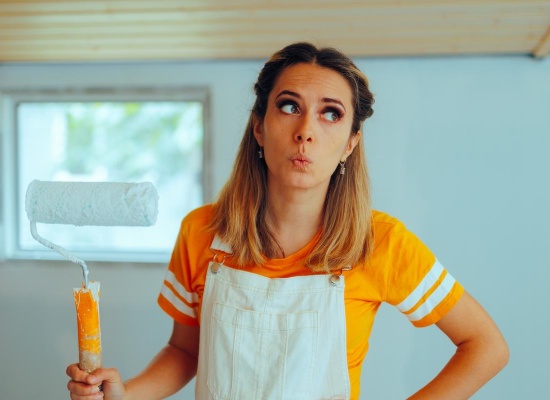 Femme tient rouleau de peinture