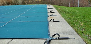 Piscine en hivernage avec une bâche.