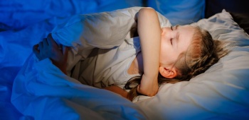 Enfant dans un lit gêné par l'humidité.