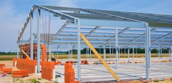 Maison en construction avec une charpente en métal.