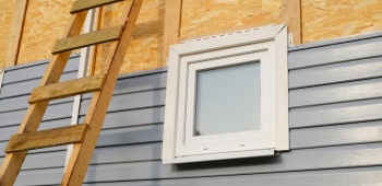 Pose de bardage en PVC sur une façade.