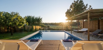 Deux transats sur une terrasse devant une piscine