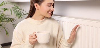 Femme qui se réchauffe près d'un radiateur