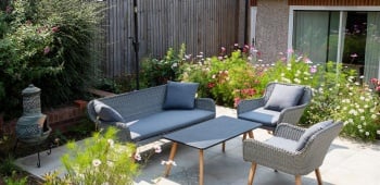 Petite terrasse devant une maison avec une table pour quatre