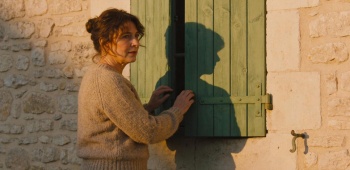 femme qui ferme ses volets battants à la fin de la journée