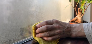 Personne nettoie la condensarion sur une fenêtre