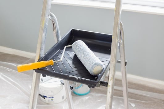Rouleau de peinture dans un bac sur un chantier