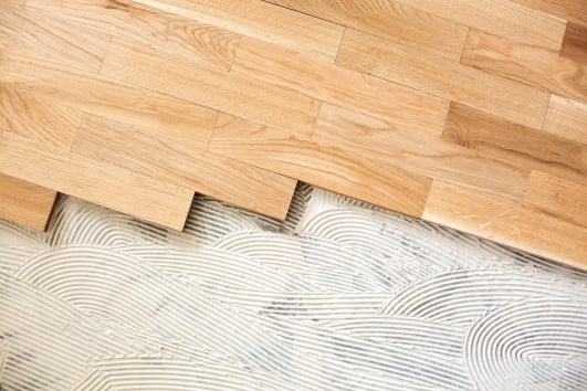 Pose collée de parquet.