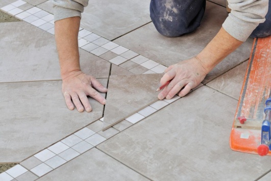 Artisan qui pose du carrelage.