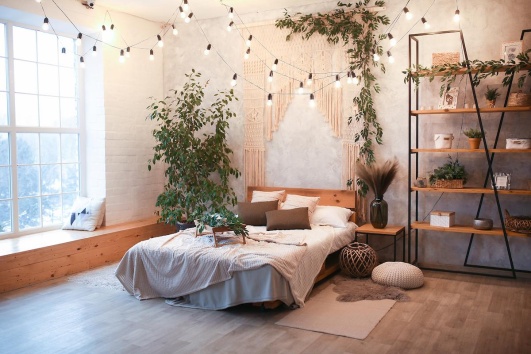 Chambre décorée dans le style bohème avec une guirlande lumineuse. 