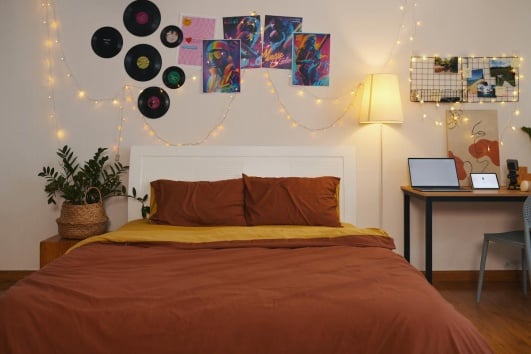 Chambre d'ado décorée avec des posters et des vinyles au mur. 