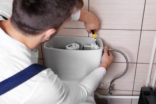Plombier réparant des toilettes