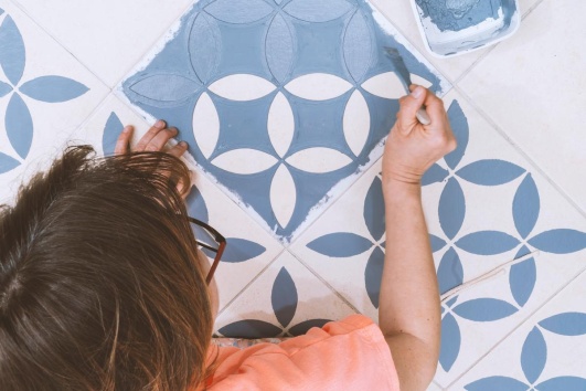 Peinture de motifs bleus sur carrelage blanc avec pochoir