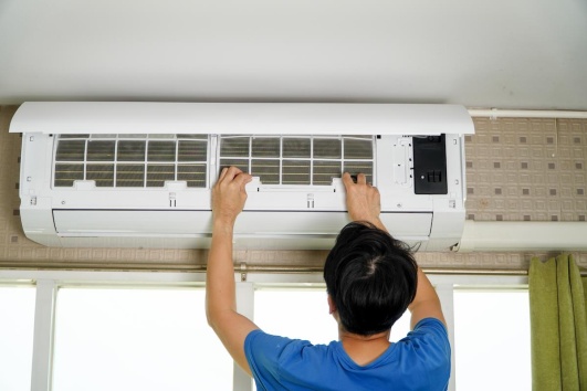 homme en train de nettoyer le filtre de son climatiseur