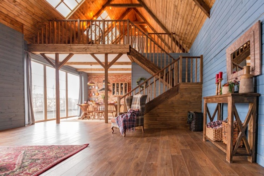 Intérieur d'une ferme rénovée en habitation, avec du parquet et un escalier en bois