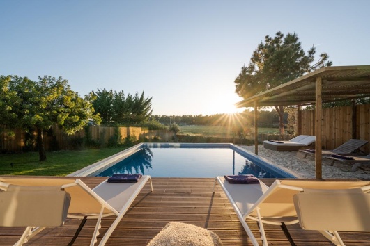 Deux transats sur une terrasse devant une piscine