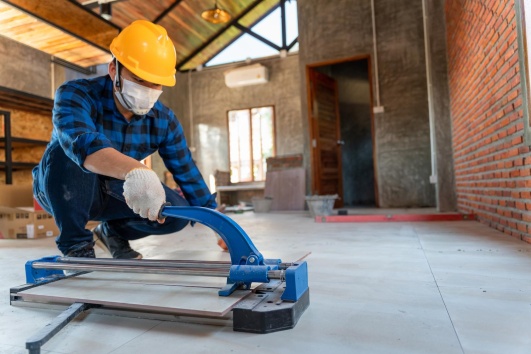 Artisan renovant le sol d'une ferme pour en faire une habitation