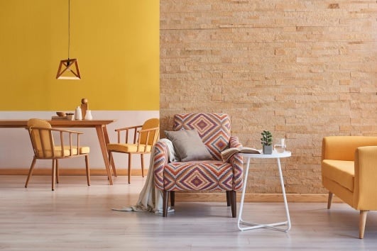 Salle à manger dont les murs sont peints en jaune curcuma