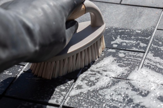 Nettoyage du carrelage extérieur avec une brosse