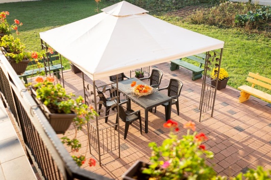 Terrasse avec tables et chaises abrités par une tonnelle