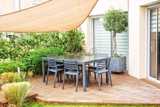 Terrasse en bois abritée par un voile d'ombrage
