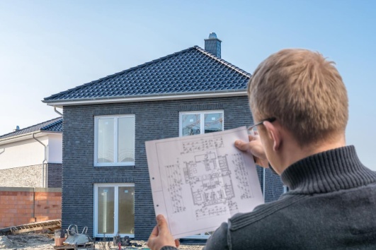 maitre d'œuvre artisan regardant le plan d'une maison