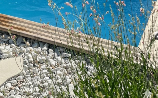 margelle en bois et revetement pierre autour de la mini piscine