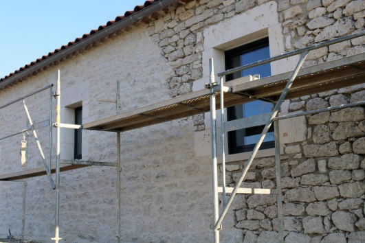 Ravalement de façade réfection mur où l'on remets progressivement des pierres