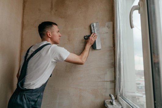homme appliquant un enduit sur un mur