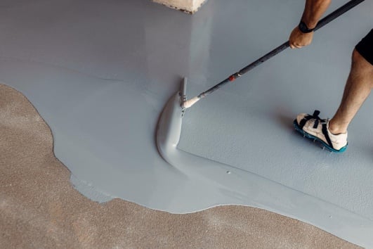 étalement béton autonivelant par un maçon professionnel