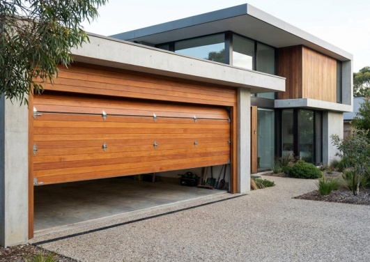 porte de garage en bois à porte sectionnelle entre ouverte dans une maison moderne