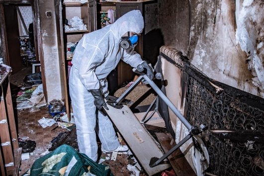 homme qui nettoie apres un incendie