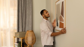 home accroche un tableau pour decorer son salon