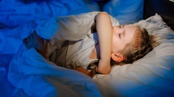 Enfant dans un lit gêné par l'humidité.