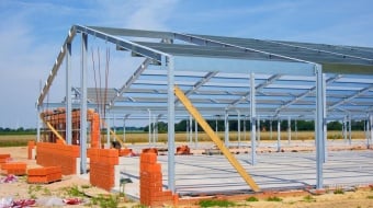 Maison en construction avec une charpente en métal.