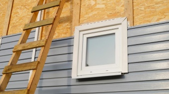 Pose de bardage en PVC sur une façade. 