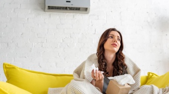 jeune femme pas en forme assise sous un climatiseur