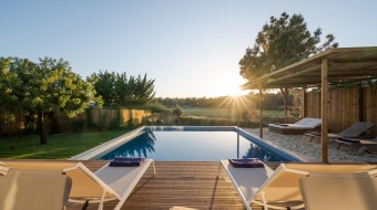 Deux transats sur une terrasse devant une piscine