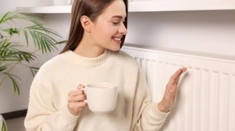 Femme qui se réchauffe près d'un radiateur