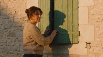 femme qui ferme ses volets battants à la fin de la journée