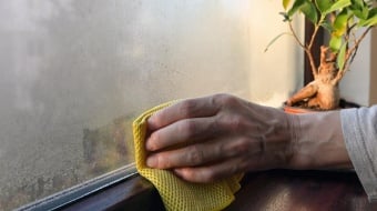 Personne nettoie la condensarion sur une fenêtre